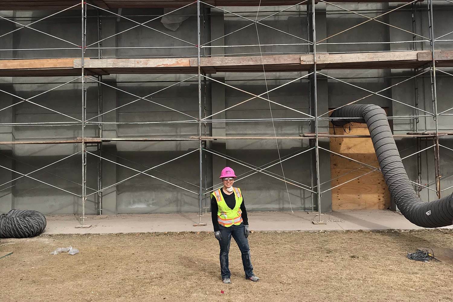 Elisha Nelms standing in front of a job site