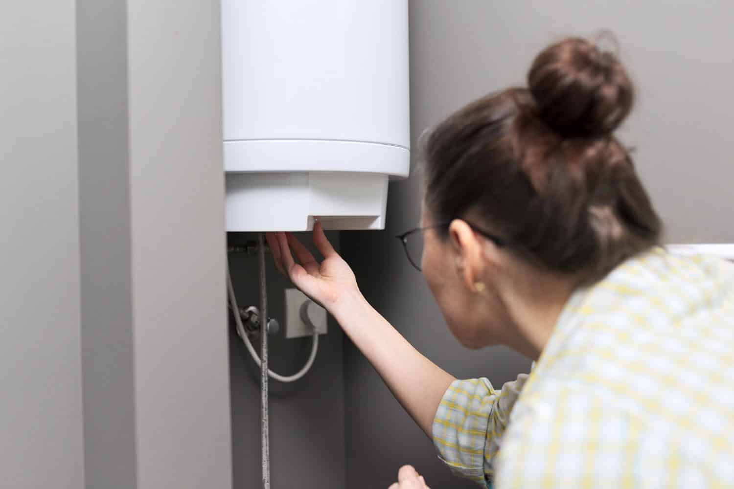 Woman inspecting hot water heater